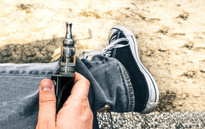 young man vaping on the beach as he battles his vaping addiction